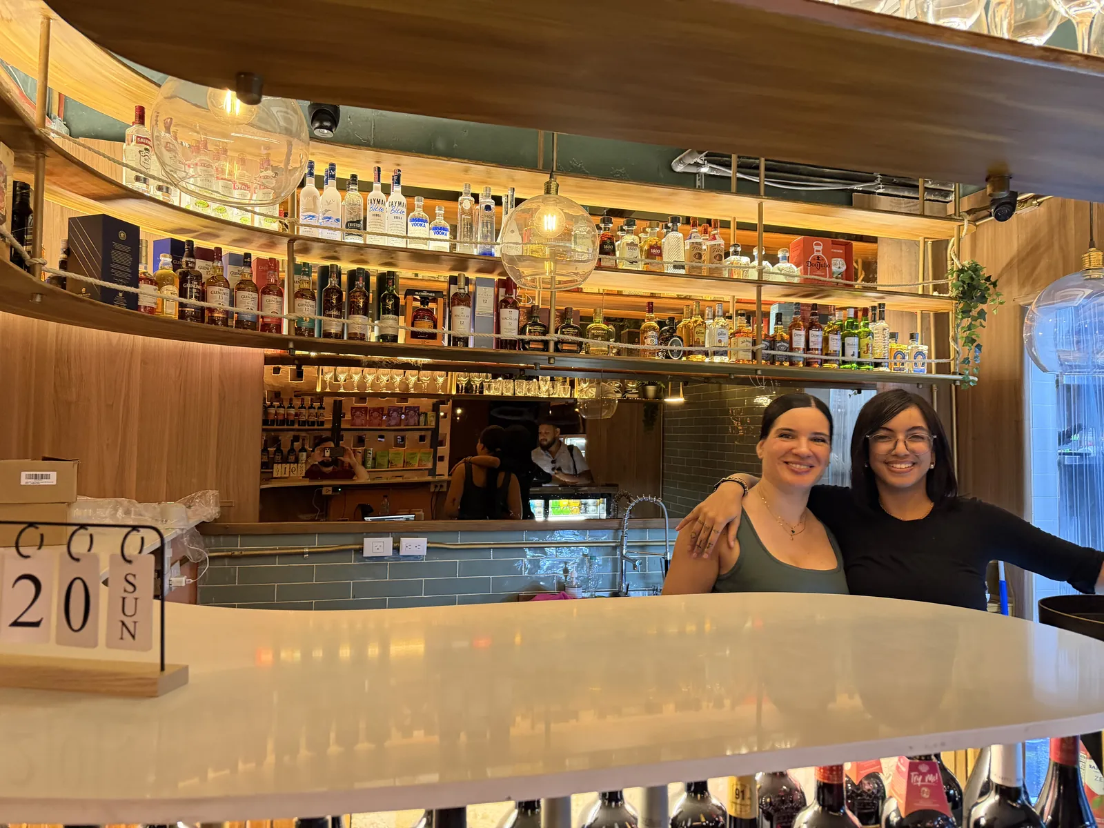 The round bar at Malecon Vibes with two of the team behind it, shelves of bottles above