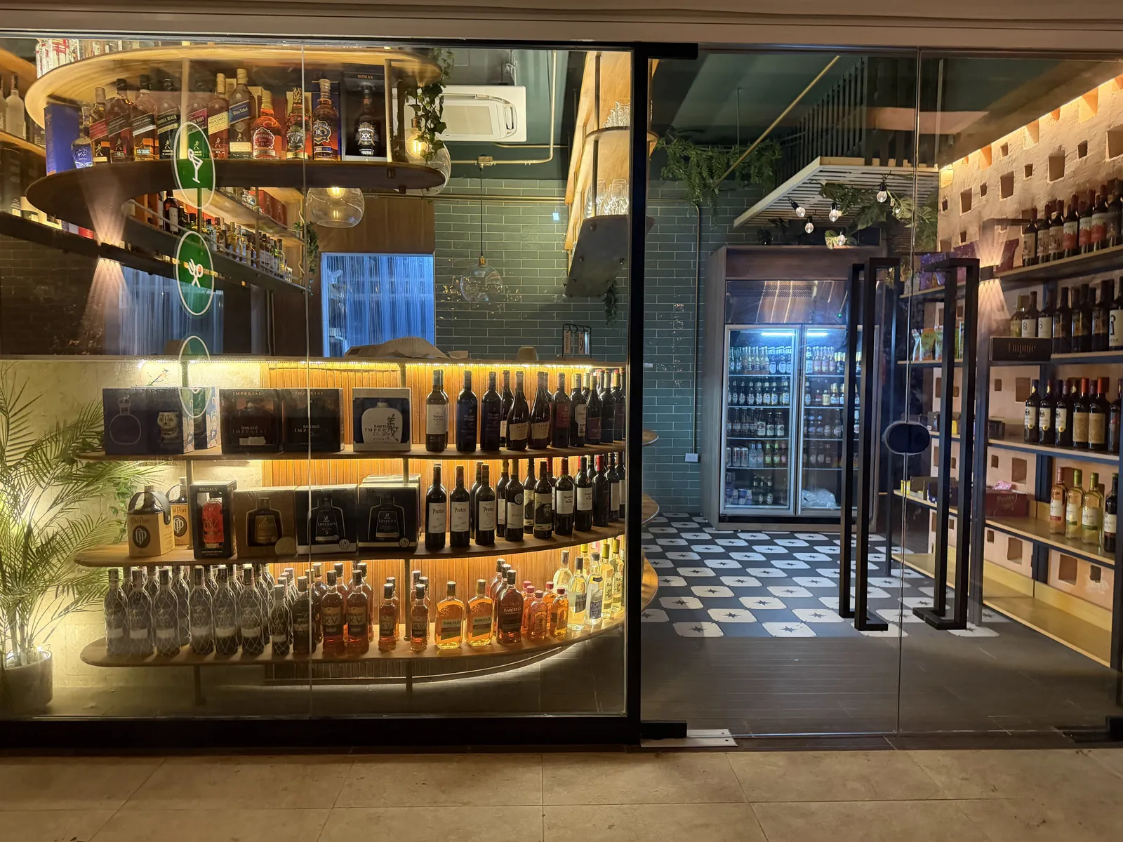 Curved shelves of wine and spirits seen through the glass front